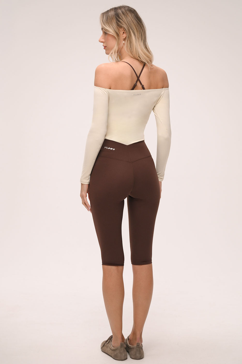 טייץ קאפרי מחטב לנשים בגזרת וי עם מותן גבוהה ומראה ספורט שיק.