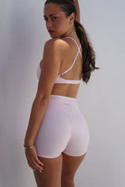 Cross Bra Duo - חזיית ספורט לנשים עם גזרת V עמוקה, עיצוב קונטרסט, קאפים נשלפים ובד מחטב וגמיש, מתאימה לאימוני כושר, פילאטיס, יוגה וללבוש יומיומי.