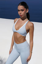 Cross Bra Duo - חזיית ספורט לנשים עם גזרת V עמוקה, עיצוב קונטרסט, קאפים נשלפים ובד מחטב וגמיש, מתאימה לאימוני כושר, פילאטיס, יוגה וללבוש יומיומי.